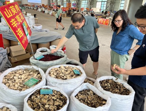 photo of bags of herbs for sale with Yvonne Lau standing next to them