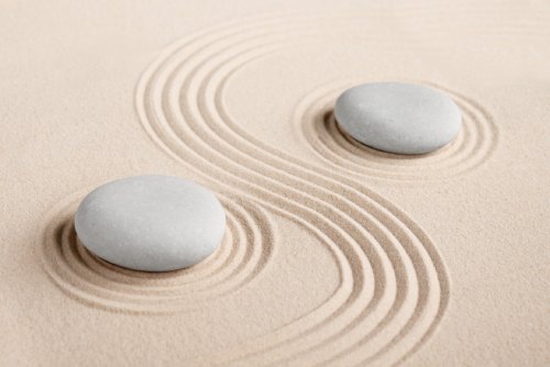 Image of rocks in the sand with curved lines around them